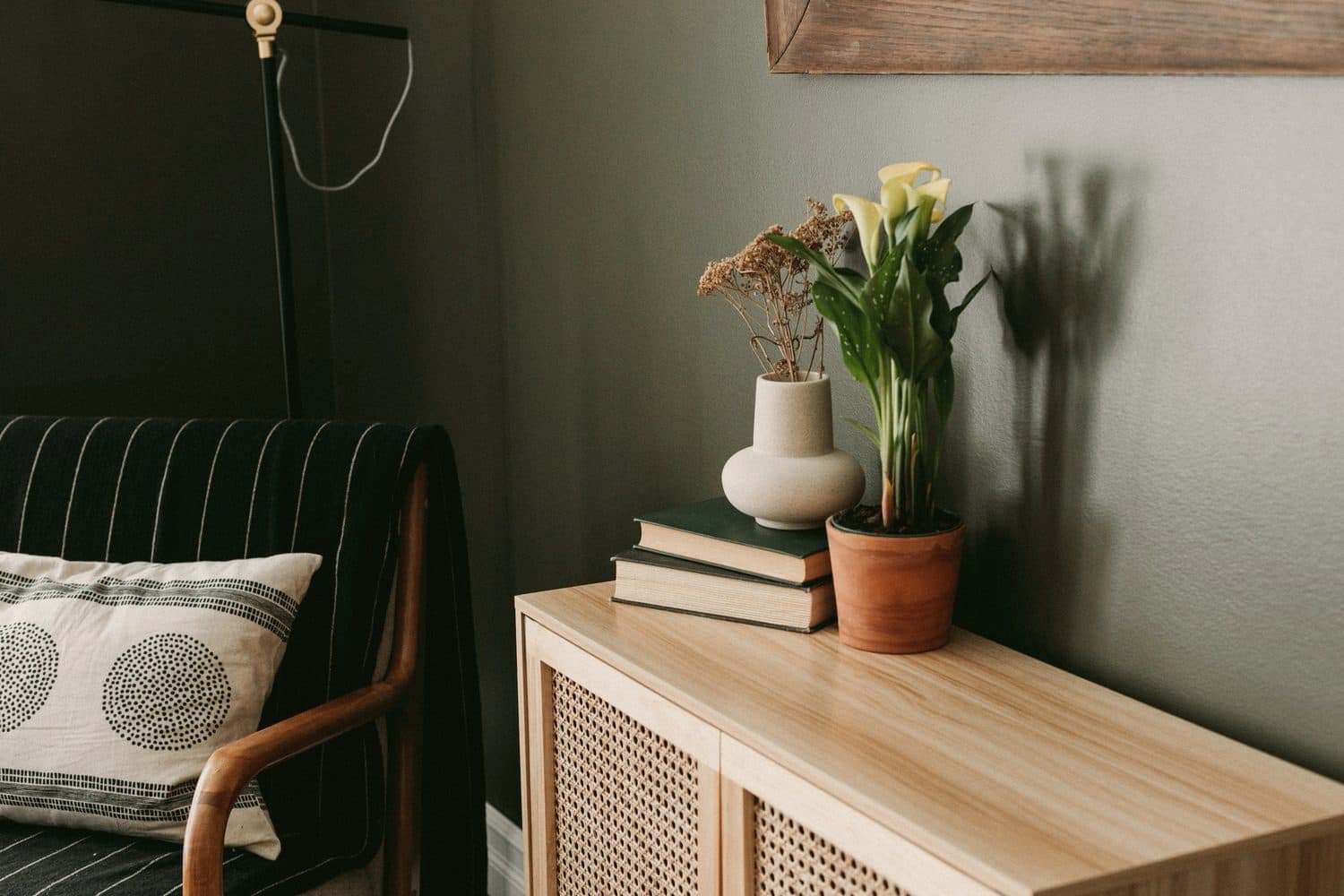 A corner of a living room with flowers and books in side light