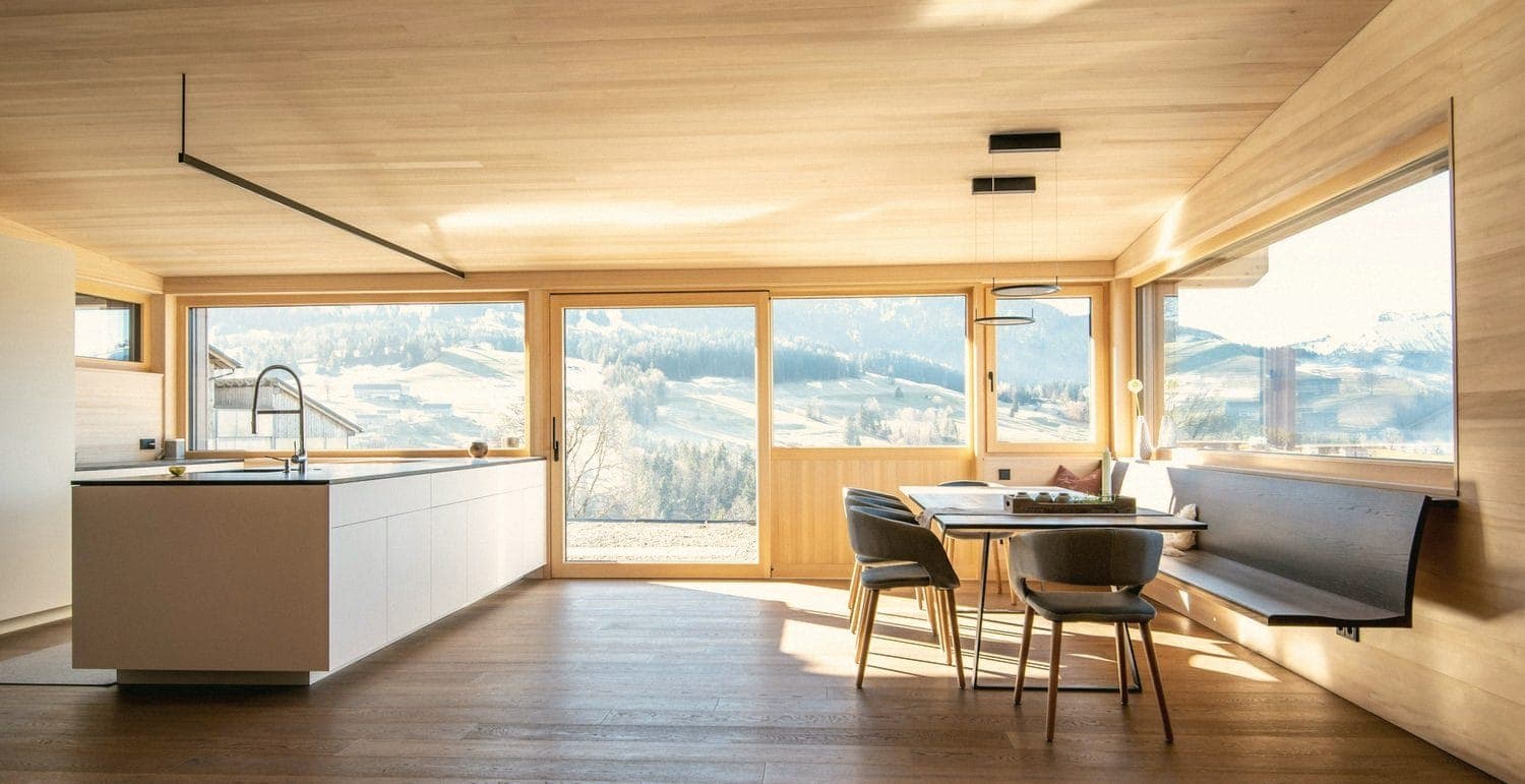 A light wood kitchen and dining room with a wide view of a valley