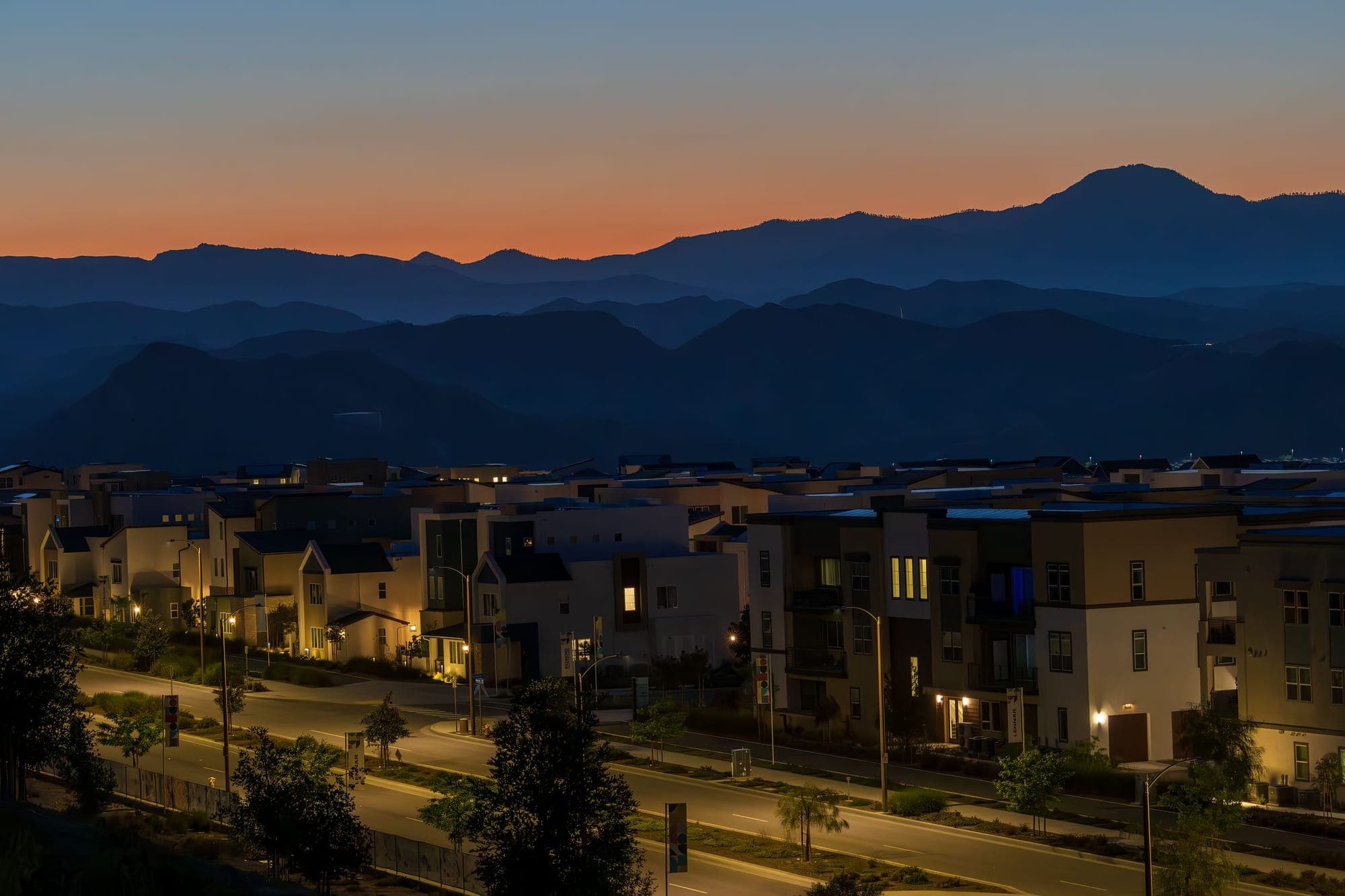 Townhomes at dusk below a mountain range