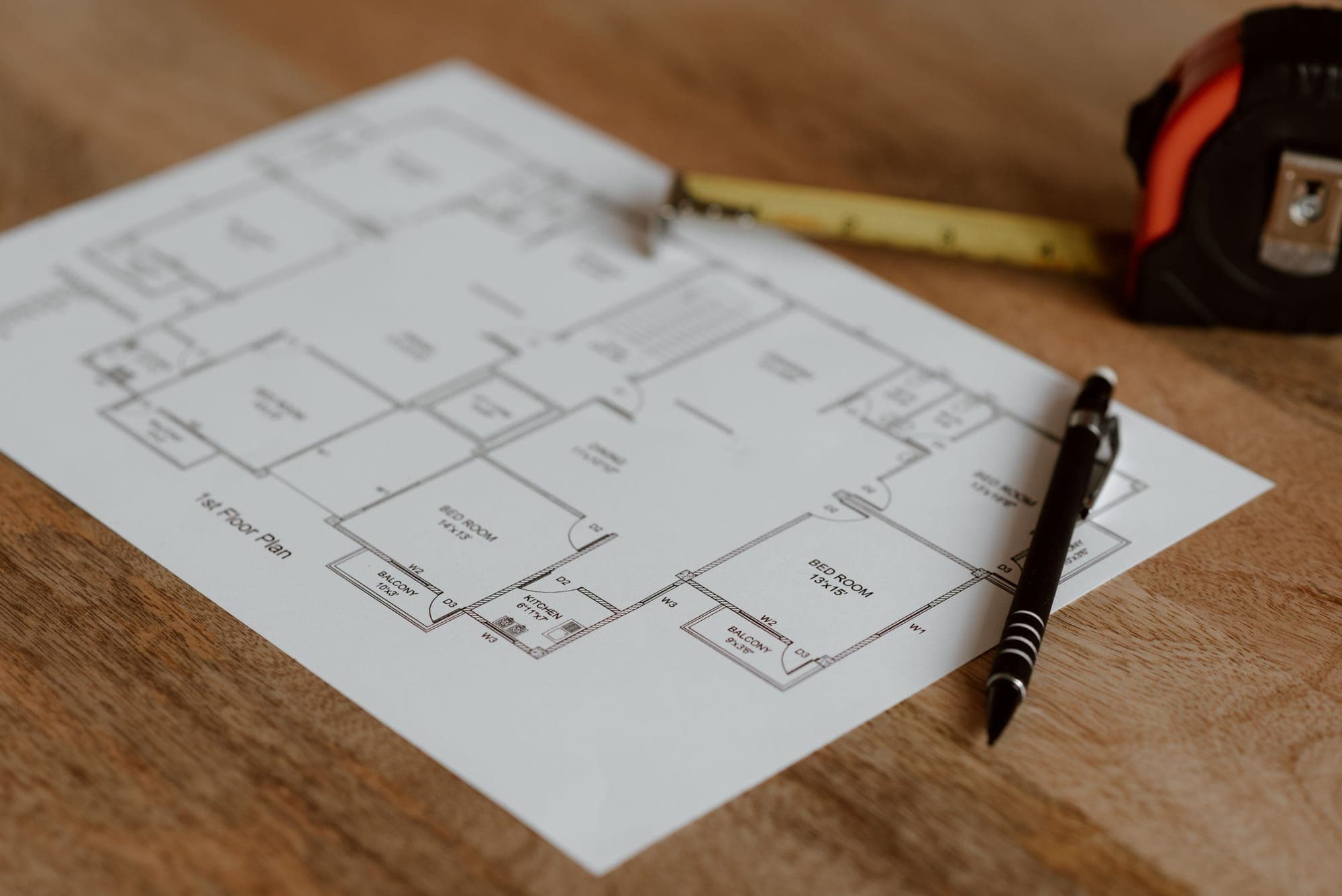 A floor plan with a pen and a tape measure